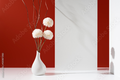 Flores de crisantemo blancas decorativas en un jarrón blanco sobre fondo rojo	