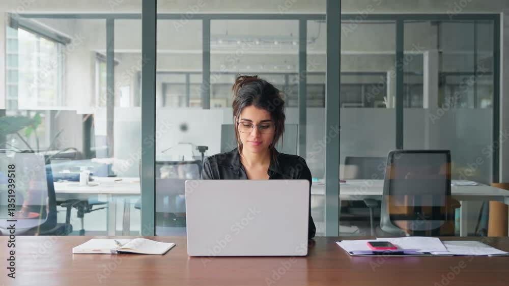 Young professional it specialist latin hispanic business lady working on laptop pc sitting at desk in modern office space. 30s middle eastern indian woman using computer technology app for work online