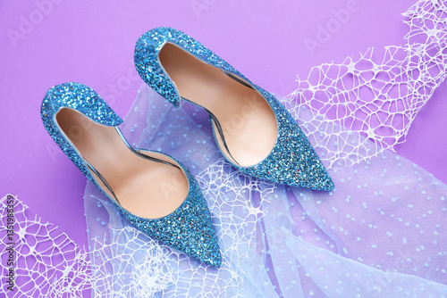 Photography Beautiful high heeled shoes, lace ribbon and tulle cloth on violet background, f