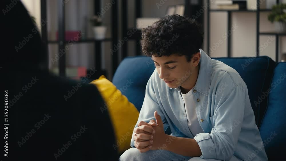 Sad teen boy sharing life struggles with a psychologist during a therapy session