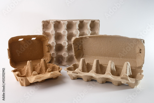Cardboard egg cartons in different styles, including open, closed, and lidless designs, emphasizing variations in packaging. raw materials for craft and DIY projects photo