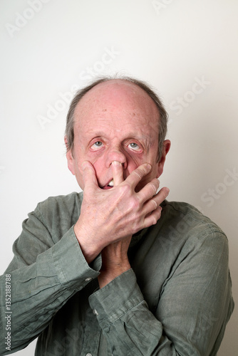 Obraz na płótnie Old man in green shirt make a ugly face in front of camera w salonie
