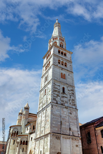 Obraz na płótnie Ghirlandina Tower alongside Modena Cathedral's rear facade. The stunning Cathedral of Modena and Torre Civica tower under a blue sky in Piazza Grande w salonie