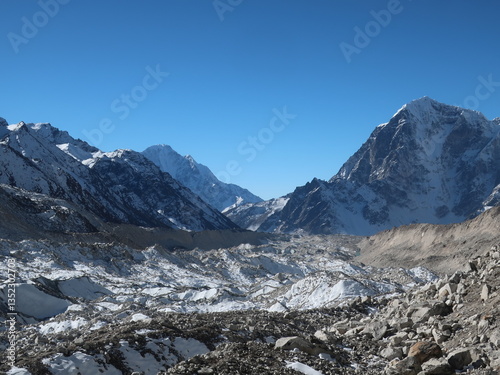 Rocky foreground and mountain peaks under clear sky