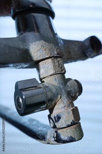 A rusty water faucet. Outdated plumbing. A broken faucet with lime coating.