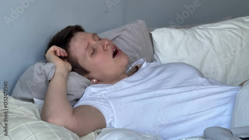young woman sleeps in bed during the day and has breathing problems, apnea, open mouth, snoringyoung woman sleeps in bed during the day and has breathing problems, apnea, open mouth, snoring