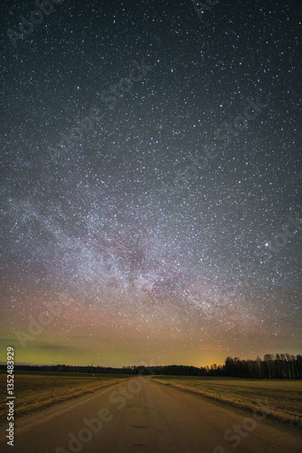 Country road at night with a gorgeous starry sky where the Milky Way is visible on a small northern light