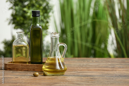 Wallpaper Mural Olives with oil on wooden table against blurred background Torontodigital.ca