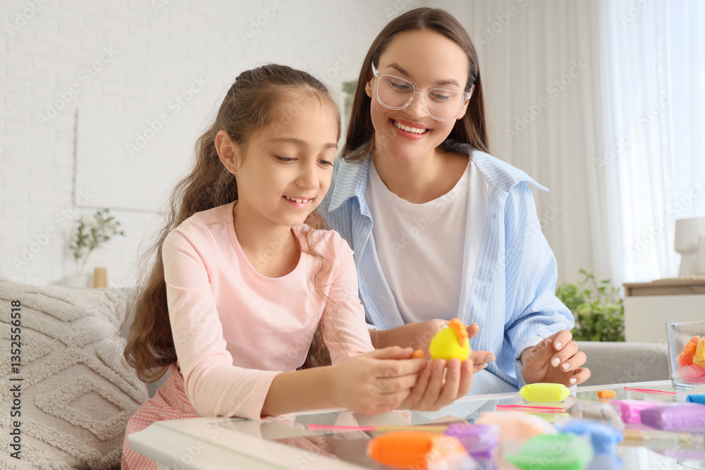 Little girl with her mother sculpting from plasticine at home Little girl with her mother sculpting from plasticine at home