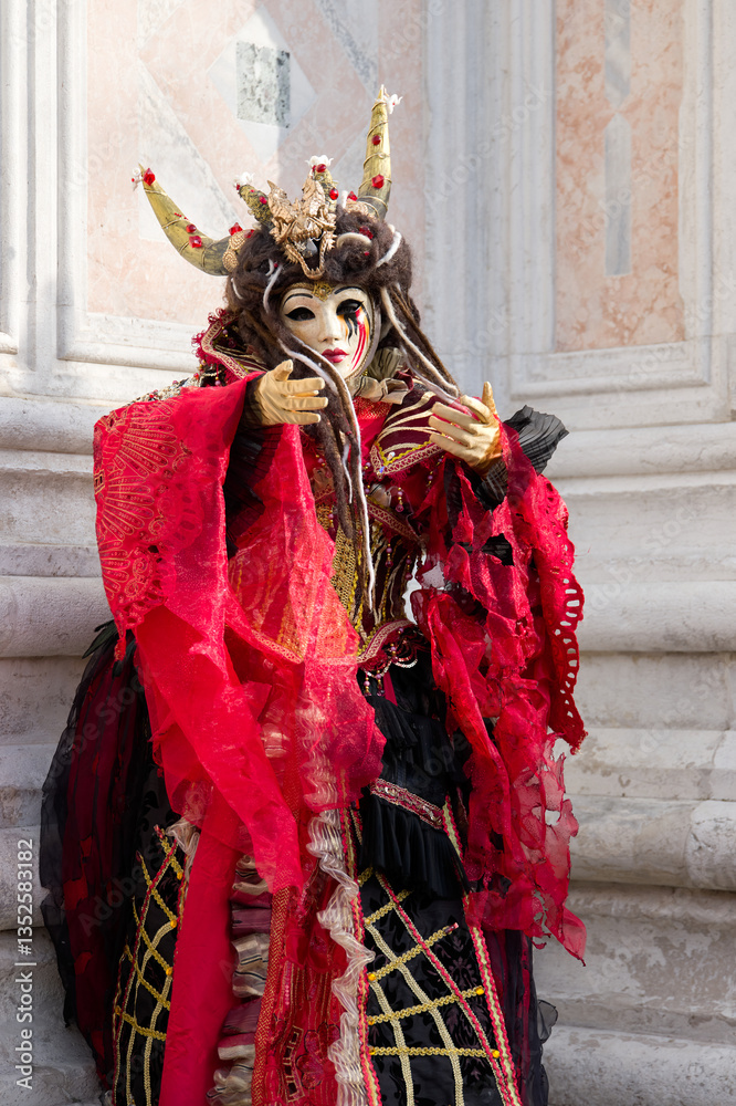 Naklejka premium Venice, Italy - People dressed in carnival masks are photographed by tourists in the scenery of the ancient Venetian palaces