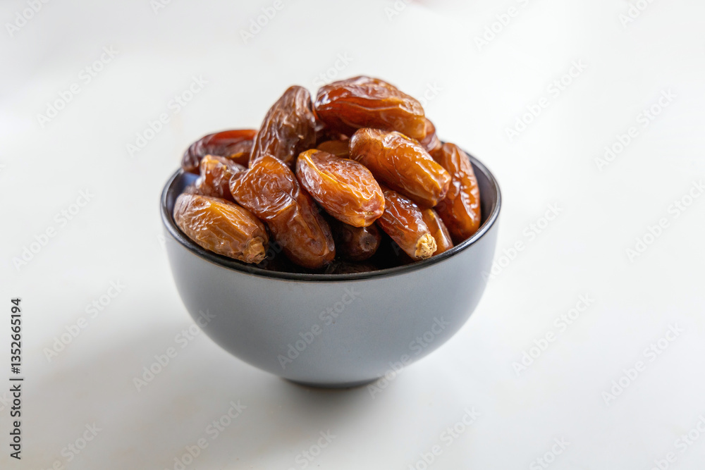 Obraz premium Delicious dates in a bowl on white