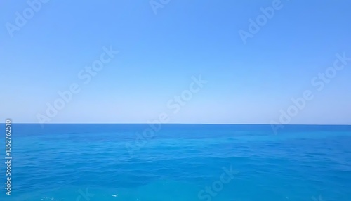 A captivating expanse of cyan sea meets a serene azure sky on the horizon
