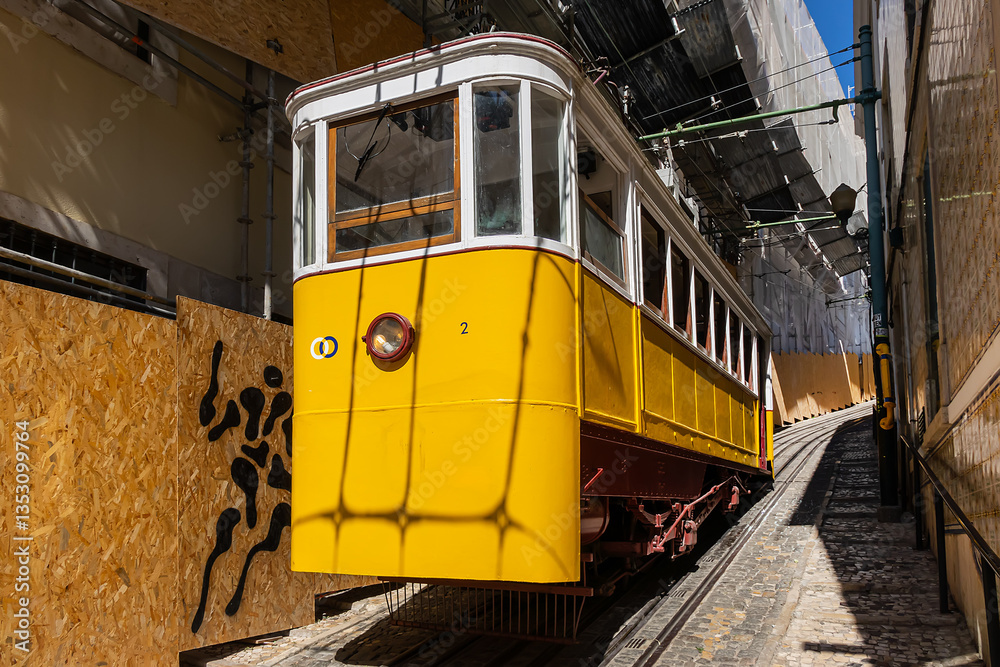 Famous retro yellow funicular in the old town. The yellow funicular operating since 1885, is a tourist attraction. Lisbon, Portugal.