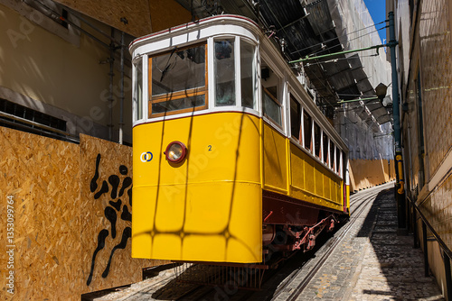 Obraz na płótnie Famous retro yellow funicular in the old town. The yellow funicular operating since 1885, is a tourist attraction. Lisbon, Portugal. w salonie