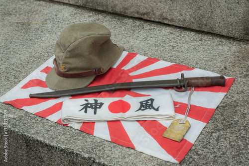 Japanese soldier's military cap, sword, banner with words of kamikaze, and national flag at war time of world war 2 displayed in yasukuni shinto shrine