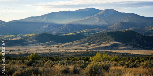A majestic mountain range with soft sunlight casting long shadows over the valleys