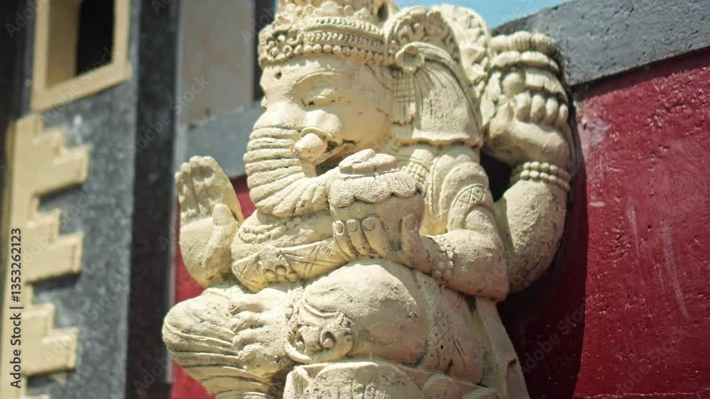 An old hindu stone statue of Ganesha covered with moss, standing on the street on the Bali An old hindu stone statue of Ganesha covered with moss, standing on the street on the Bali