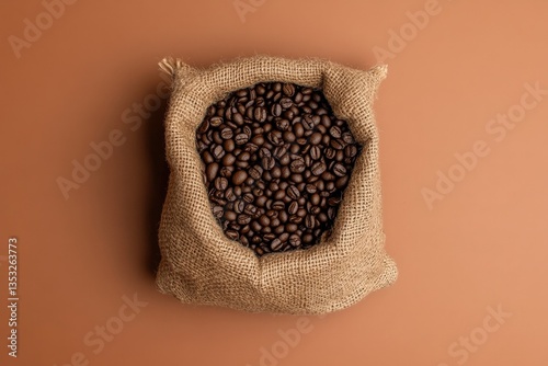 Roasted coffee beans fill a burlap sack on a brown background photo