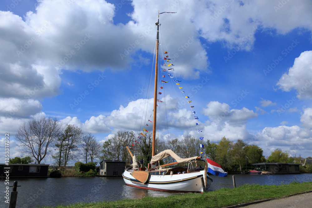 Europe, Netherlands, near Alkmaar. Dutch Flag on sailboat.