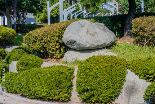 Rocks nestled in bushes in a landscaped garden.