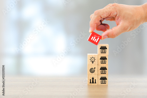 Hand chooses graph icon on wooden toy stack with franchise business store for franchising to growth branch expansion and business banking loan or consumer resources service.