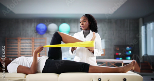 Obraz na płótnie Physio treating young Black woman's knee injury w salonie