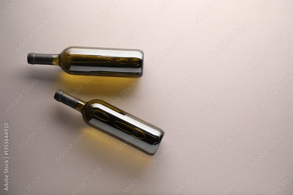Bottles of wine on light grey background, flat lay. Space for text Bottles of wine on light grey background, flat lay. Space for text