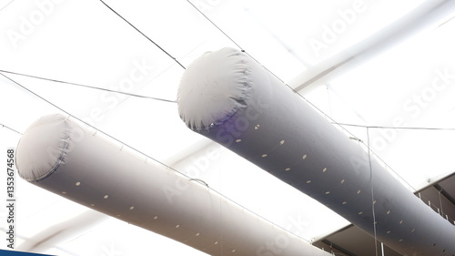 Frabic air duct. Close up of grey twin fabric air ducts hanging on white canvas dome in exhibition low angle with selective focus.