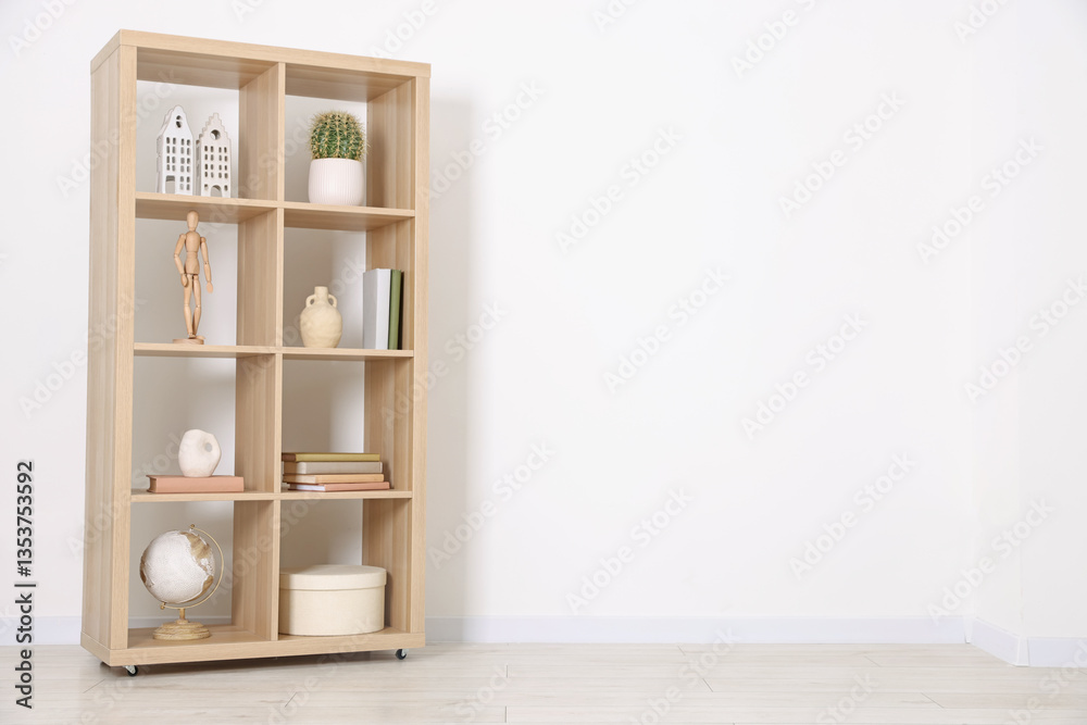 Fototapeta premium Shelving unit with different home decor near white wall indoors, space for text