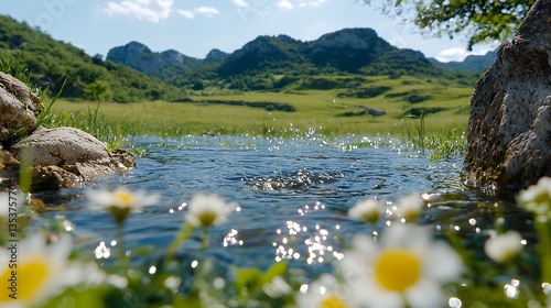Tranquil Water with Wildflowers Under Blue Summer Sky Near Green Hills