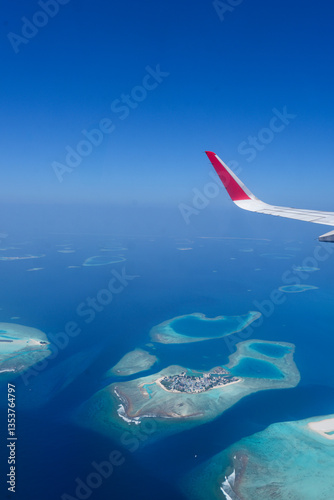 Scenery view of Maldives islands top view from airplane wing flying in the blue sky above Maldives island