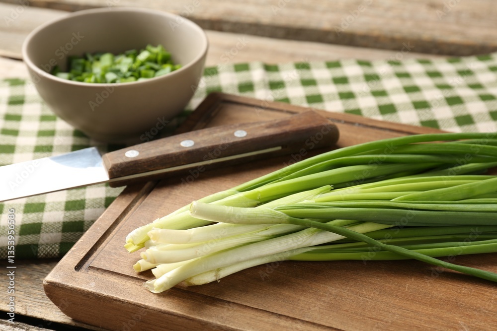 Fresh green onions and knife on wooden table, closeup Fresh green onions and knife on wooden table, closeup