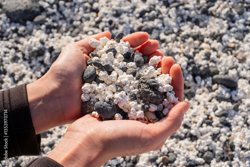 White popcorn-shaped stones in a woman's hand forming a heart