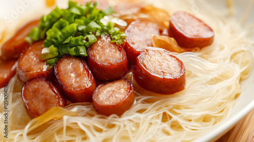 Close-up of rice noodles topped with sausage and scallions