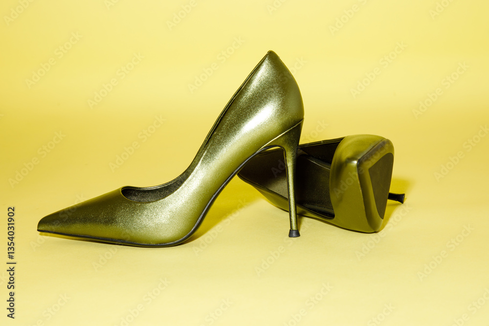 Green high hill shoe against yellow background.
