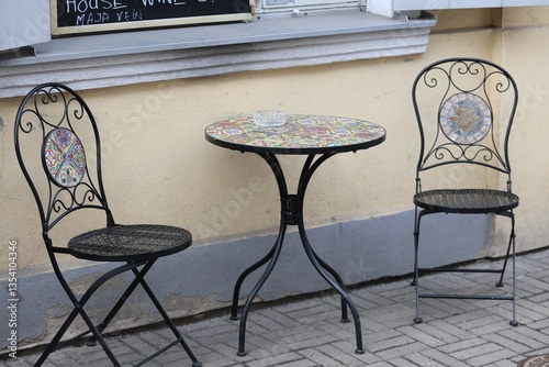 two chairs and a table on the side of the street