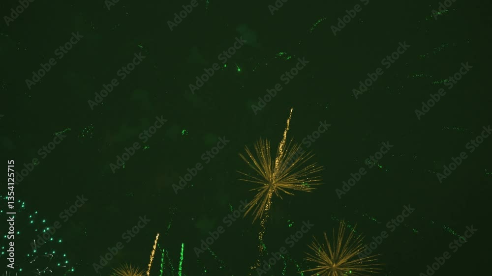Fireworks in evening sky during celebration. The colors are yellow and green