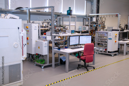 Industrial research lab with multi-screen data workstation, control panels, and testing infrastructure for precision monitoring and smart product engineering workflows