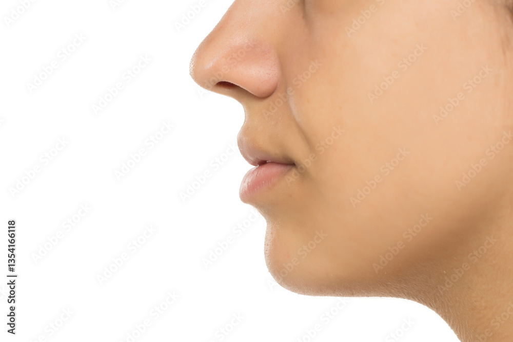 Obraz premium Profile view of female facial features showing nose, lips, and skin texture. Natural, no makeup look with soft lighting. Clean, minimal skincare concept