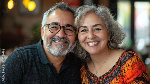 hispanic elderly couple smiling and looking at camera sharing joy and togetherness showcasing senior lifestyle happiness relationship bond and emotional connection in their golden age