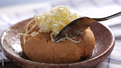 Irresistible Cream Puff Moment. Watch the Soft Choux Pastry Open to Reveal a Rich, Smooth Cream and Cheesy Goodness. Focuses on the moment the spoon cuts through and reveals the filling.