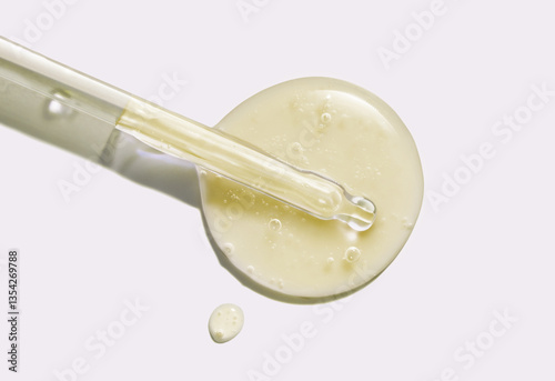 Liquid yellow gel or serum with pipette dropper on grey isolated background