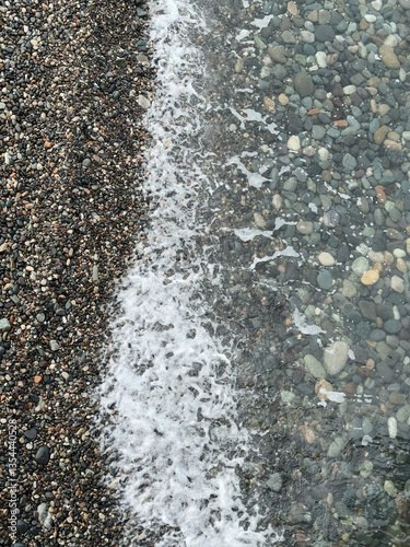 Obraz na płótnie Gentle waves washing over a pebble beach w salonie