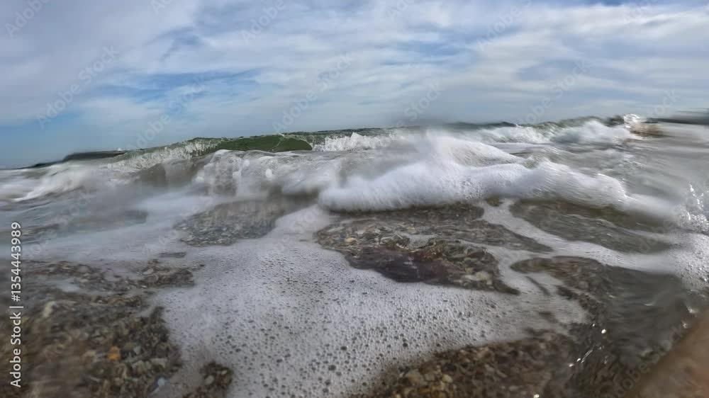 Hydrodynamic movement of sand near the shore on the beach, sand and pebbles move in the waves in the Black Sea, Odessa Hydrodynamic movement of sand near the shore on the beach, sand and pebbles move in the waves in the Black Sea, Odessa