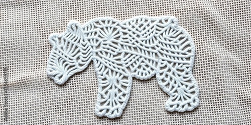 Plakat Intricate white thread bear embroidery pattern on natural fabric, rustic, needlework