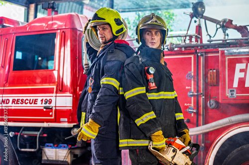 Firefighters in fire fighter safety suit stand in front of Fire truck in emergency situation.. - Safety Firefighter and industrial concept.