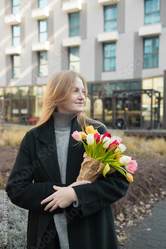 Obraz na płótnie Beautiful happy Caucasian woman smelling bunch of tulips with closed eyes. High quality w salonie