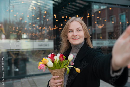 Obraz na płótnie Amazed young woman extremely happy making selfie on smart phone with fresh flowers. Excited girl looking at phone screen and pleased rejoices received great news w salonie