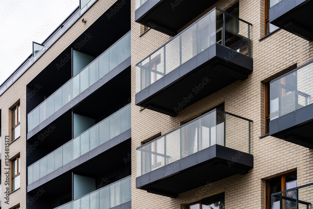 Angled view of apartment building with dark glass balconies and light brick facade, urban architecture Angled view of apartment building with dark glass balconies and light brick facade, urban architecture