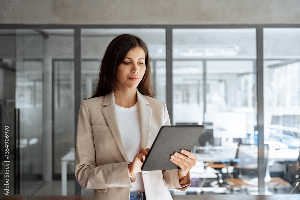 Obraz premium Focused young specialist businesswoman manager using pc tablet for sales management, financial operations, online banking. Latin or middle eastern elegant business woman working on computer at office